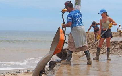 Workers in Peru clean up after a storm as a coastal El Niño impacted the coast